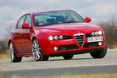 Czerwona Alfa Romeo 159 z włączonymi światłami, widoczne żarówki alfa 159.