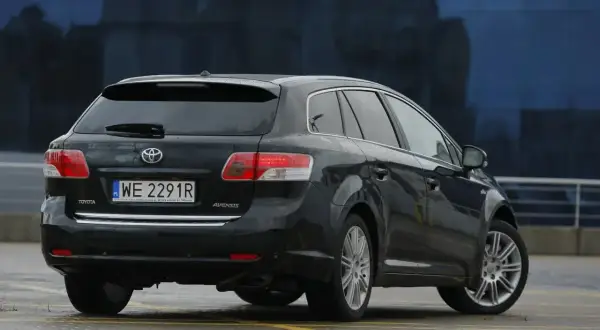 Czarne kombi Toyota Avensis T27 z polskimi tablicami WE 2291R. Widać tylne światła i felgi.