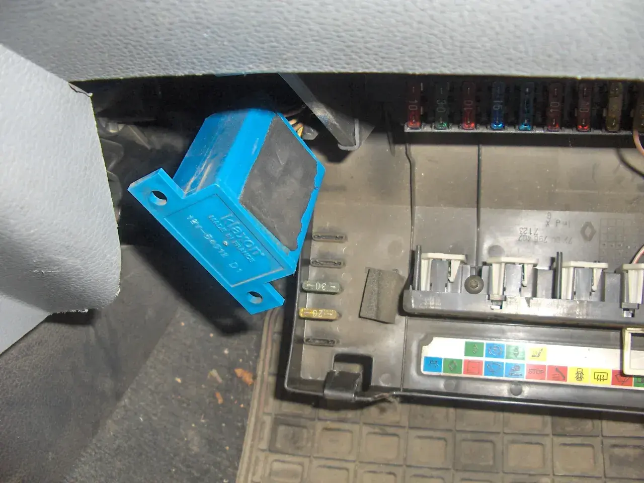 Wymiana bezpiecznika świateł mijania w Renault Clio 3. Widoczny niebieski przekaźnik i skrzynka bezpieczników.