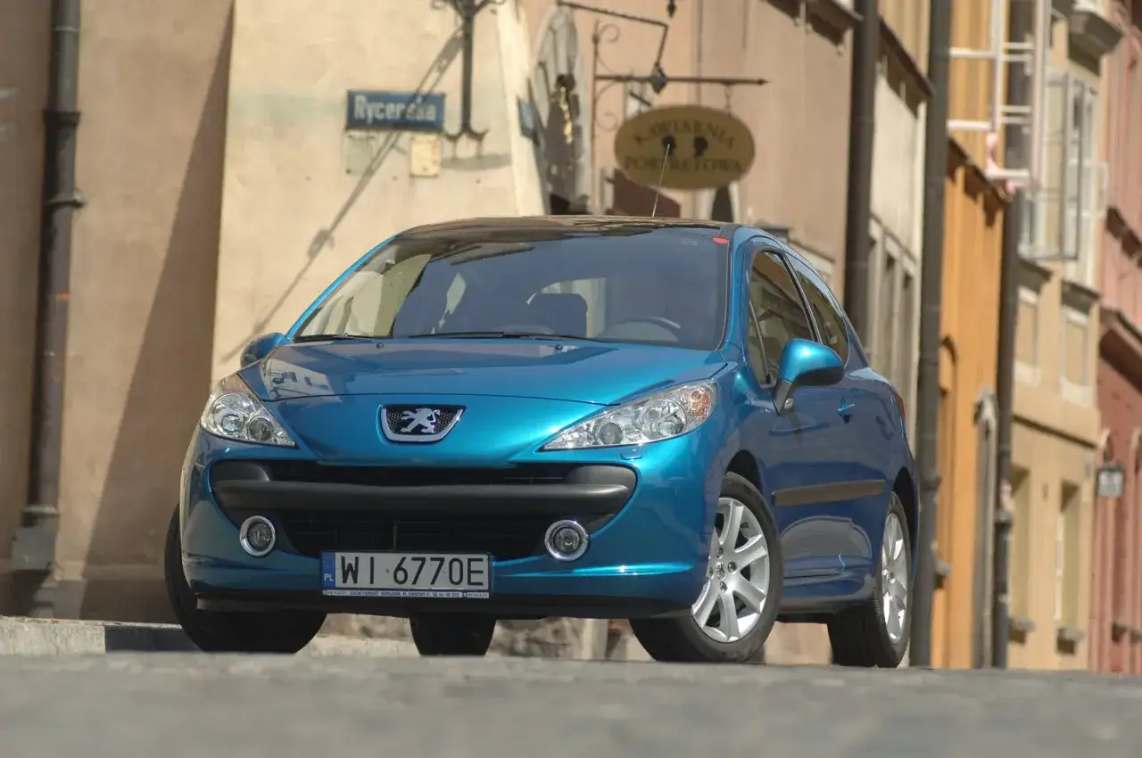 Niebieski Peugeot 207 na ulicy. Wymiana żarówki peugeot 207 przód może być konieczna, gdy światła zaczną słabiej świecić.