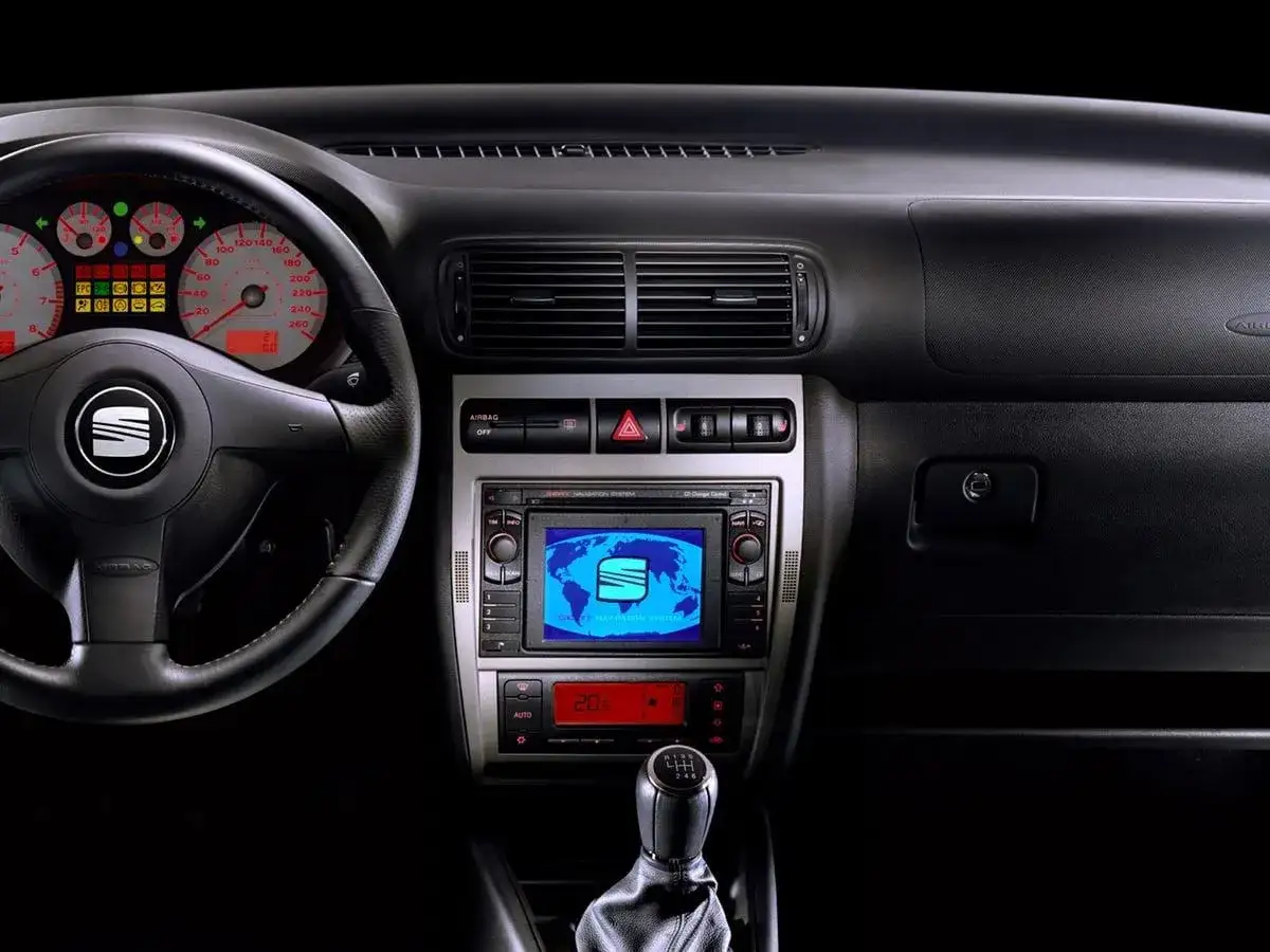 Wnętrze Seat Leon 2000: kierownica, zegary, radio z nawigacją i dźwignia zmiany bieg&oacute;w.