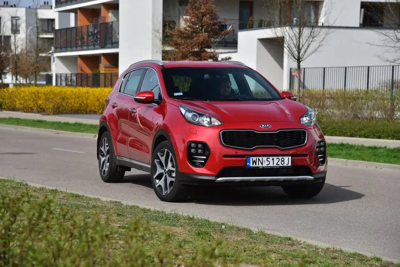 Czerwony Kia Sportage 4 na drodze, gotowy do wymiany żar&oacute;wki.