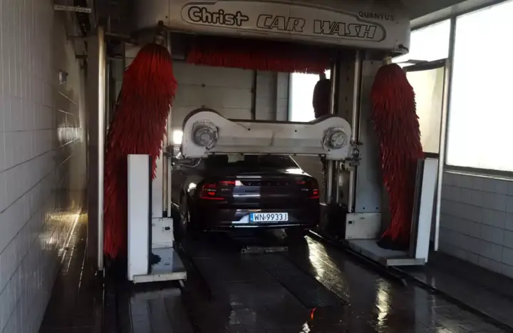 Samochód wjeżdża do myjni automatycznej. Czas dowiedzieć się, jak umyć samochód, by lśnił czystością!